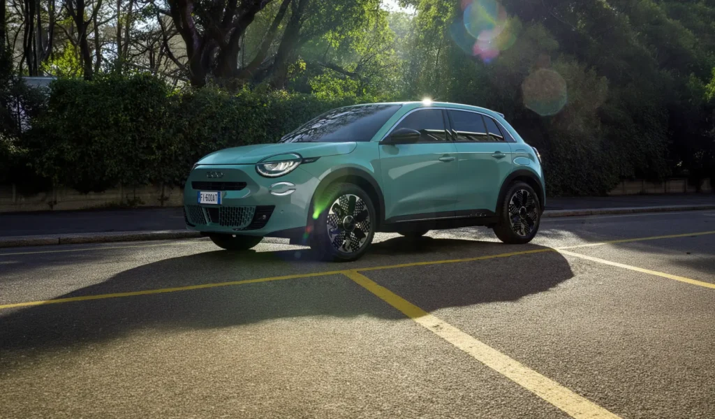 fiat 600 azzurra parcheggiata vicino ad una siepe